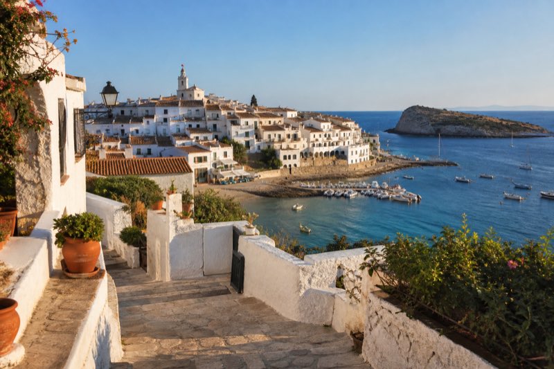 White coastal village above a blue island harbor